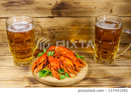 Boiled crayfish and two mugs of beer on a wooden table Boiled crayfish and two mugs of beer on a wooden table 137441992