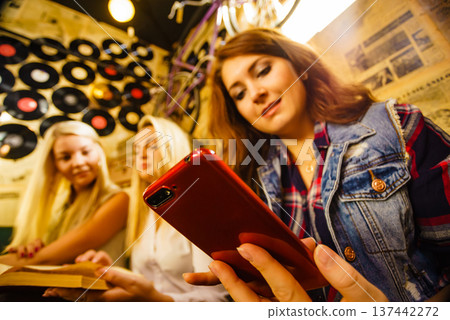 Girl in pub using smart phone Girl in pub using smart phone 137442272