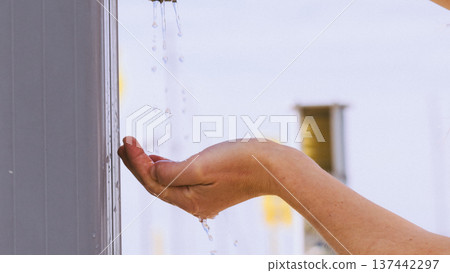 Woman drinking water from street tap 137442297