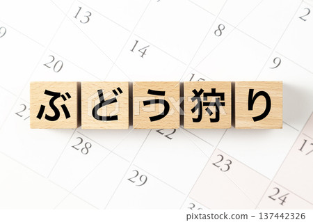 一塊寫著「採摘葡萄」字樣的積木和一個日曆 一塊寫著「採摘葡萄」字樣的積木和一個日曆 137442326