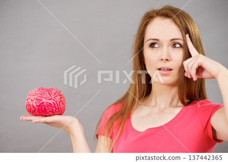 Woman thinking holds brain 137442365