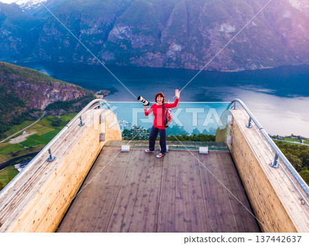 Tourist enjoying fjord view on Stegastein viewpoint Norway 137442637