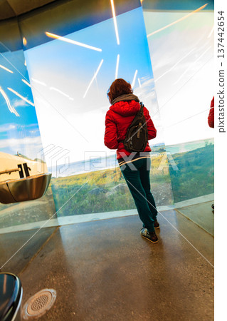 Tourist look out at landscape from mirrored toilet, Andoya Norway Tourist look out at landscape from mirrored toilet, Andoya Norway 137442654