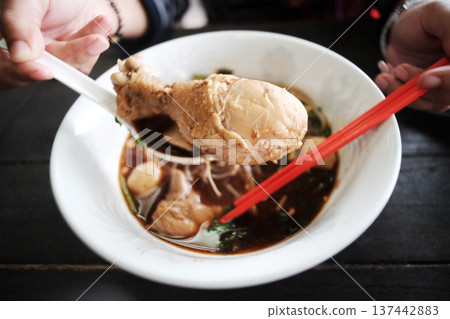 Hand holding Chicken thighs of Noodles with braised chicken in white bowl Hand holding Chicken thighs of Noodles with braised chicken in white bowl 137442883