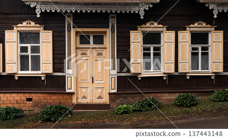 Traditional Wooden House Facade with Ornate Windows and Door 137443148