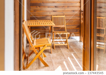 balcony with wooden table and chairs 137443545