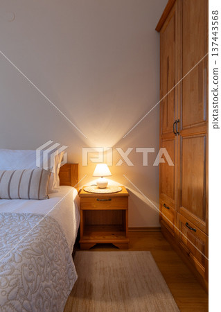 Bedroom lamp on night stand near sleeping bed 137443568