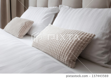 White and gray soft pillows on the bed 137443569