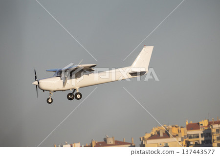 White single engine propeller aircraft flying in blue sky White single engine propeller aircraft flying in blue sky 137443577