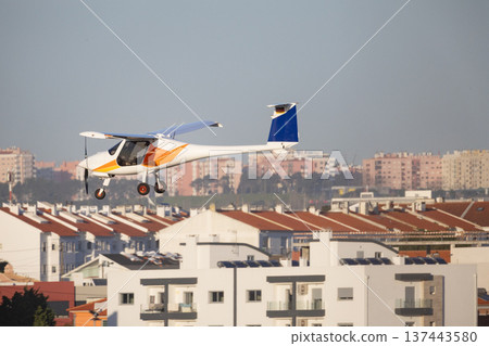 Ultralight aircraft flying over residential city buildings Ultralight aircraft flying over residential city buildings 137443580