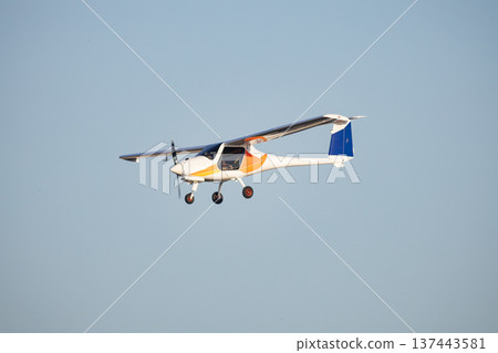 Light sport aircraft flying against clear blue sky Light sport aircraft flying against clear blue sky 137443581