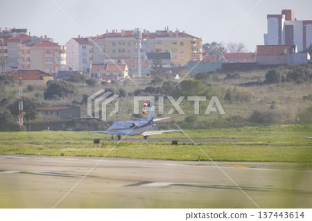 Private business jet taxiing on airport runway 137443614