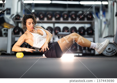 Woman doing core exercise on gym floor workout Woman doing core exercise on gym floor workout 137443690