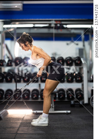 Fit woman training back muscles in gym 137443728