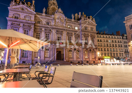 Lyon, france. December 27, 2023. Lyon city hall illuminated at night, seen from an outdoor cafe terrace in place des terreaux, highlighting european city life 137443921
