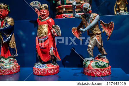 Lyon, france. December 27, 2023. Colorful chinese folk deity statues displayed in a museum setting, ornate painted ceramic figures representing cultural mythology and heritage 137443929