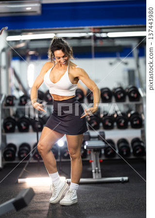 Fit woman showing body posing at modern gym 137443980