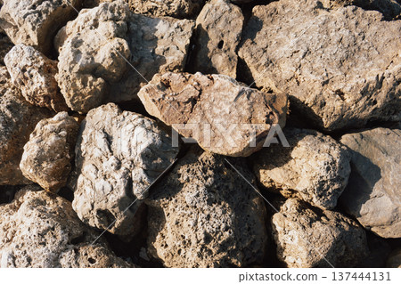 Dry ancient limestone rocks texture background pattern under harsh summer sunlight and shadows Dry ancient limestone rocks texture background pattern under harsh summer sunlight and shadows 137444131
