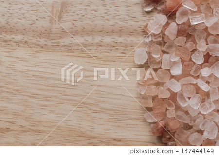 Coarse Himalayan pink salt crystals scattered on a natural wood surface. Tactile organic composition with warm timber grain, coral mineral tones, and copy space Coarse Himalayan pink salt crystals scattered on a natural wood surface. Tactile organic composition with warm timber grain, coral mineral tones, and copy space 137444149