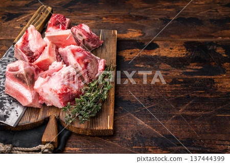 Raw diced Beef meat with bones for stew or goulash on wooden board. wooden background. top view Raw diced Beef meat with bones for stew or goulash on wooden board. wooden background. top view 137444399