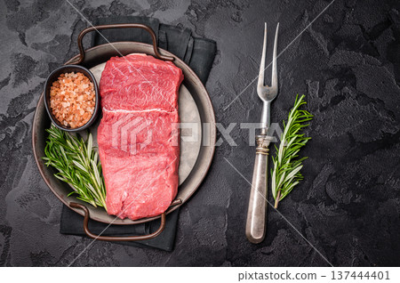 A selection of raw bison steaks arranged artfully, emphasizing their quality and texture, inviting culinary creativity in the kitchen. black background. top view A selection of raw bison steaks arranged artfully, emphasizing their quality and texture, inviting culinary creativity in the kitchen. black background. top view 137444401