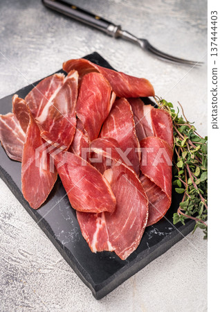 Sliced Speck bacon, Italian cured meat. grey background. top view Sliced Speck bacon, Italian cured meat. grey background. top view 137444403