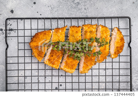 Tender chicken cutlet katsu, coated in crunchy breadcrumbs and fried to perfection. Ideal for a satisfying meal or as a topping for rice. grey background. top view 137444405
