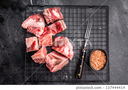 Raw lamb mutton meat and bones for stew or goulash. black background. top view Raw lamb mutton meat and bones for stew or goulash. black background. top view 137444414