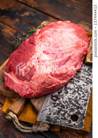 Fresh raw boneless beef shank displayed on a wooden cutting board, showcasing its rich color and marbling, perfect for hearty soups and stews. wooden background. top view Fresh raw boneless beef shank displayed on a wooden cutting board, showcasing its rich color and marbling, perfect for hearty soups and stews. wooden background. top view 137444415