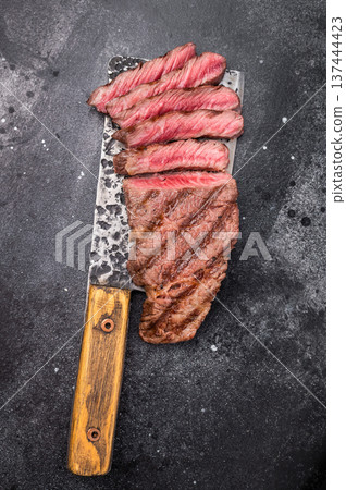 Savory shoulder steak Denver, beautifully cooked on the grill, highlighting its marbled texture and succulent taste. black background. top view Savory shoulder steak Denver, beautifully cooked on the grill, highlighting its marbled texture and succulent taste. black background. top view 137444423