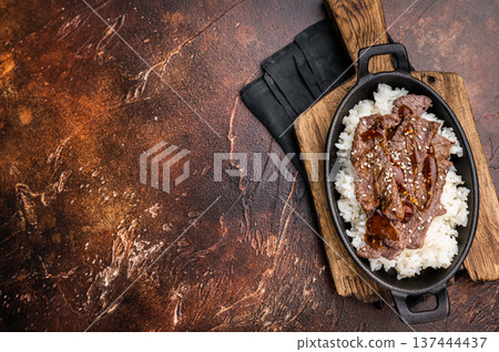 Exquisite Japanese BBQ, highlighting beautifully charred meats and rice. Perfectly seasoned, this dish promises a rich and savory flavor in every bite. brown background. top view Exquisite Japanese BBQ, highlighting beautifully charred meats and rice. Perfectly seasoned, this dish promises a rich and savory flavor in every bite. brown background. top view 137444437