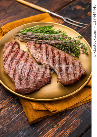 Juicy Denver, chuck eye steak, expertly grilled to perfection, offering a mouthwatering aroma and a deliciously charred exterior. wooden background. top view Juicy Denver, chuck eye steak, expertly grilled to perfection, offering a mouthwatering aroma and a deliciously charred exterior. wooden background. top view 137444446