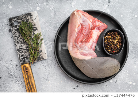 Raw beef tongue meat with spices and herbs on black plate. Traditional offal product used in gastronomy. Raw beef tongue meat with spices and herbs on black plate. Traditional offal product used in gastronomy. 137444476