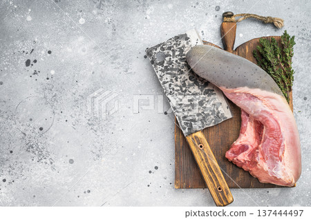 Raw beef tongue on wooden board with cleaver and fresh thyme. Traditional organ meat preparation scene with copy space. Raw beef tongue on wooden board with cleaver and fresh thyme. Traditional organ meat preparation scene with copy space. 137444497