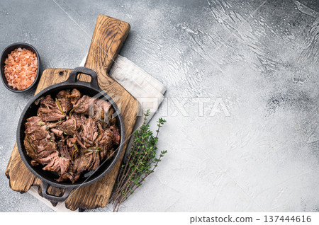 Slow cooked Shredded beef ragu in a skillet. grey background. top view Slow cooked Shredded beef ragu in a skillet. grey background. top view 137444616