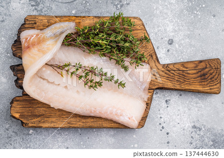 Fresh cod fish fillet, showcasing its delicate texture and pristine color, perfect for grilling or baking. grey background. top view 137444630
