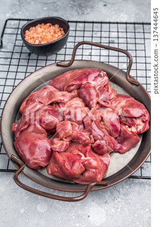 Raw poultry liver, chicken offals beautifully displayed, ready for seasoning. A nutritious ingredient ideal for gourmet dishes and traditional recipes. grey background. top view 137444645