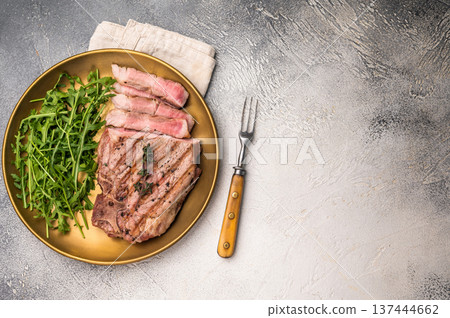 Roasted BBQ pork neck meat steak on plate with salad. grey background. top view Roasted BBQ pork neck meat steak on plate with salad. grey background. top view 137444662