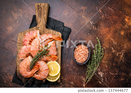 Fresh raw Headless Red Argentine shrimps, Prawns on wooden board. brown background. top view Fresh raw Headless Red Argentine shrimps, Prawns on wooden board. brown background. top view 137444677