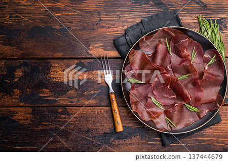 Spanish tapa Cecina meat slices, beef jamon on plate with herbs. wooden background. top view 137444679