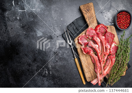 Raw mutton cutlets, fresh lamb meat chops on a wooden board. black background. top view Raw mutton cutlets, fresh lamb meat chops on a wooden board. black background. top view 137444681