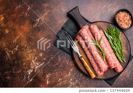 Fresh raw beef and lamb meat kebabs sausages on wooden board. brown background. top view 137444684