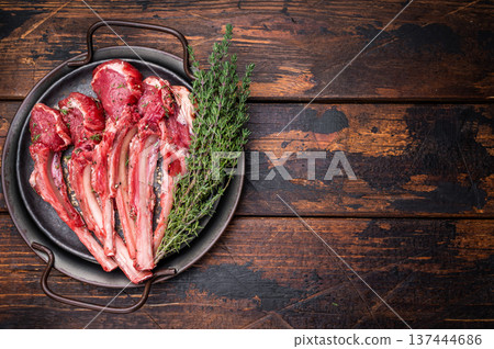 Raw lamb chop cutlets, fresh mutton meat for steaks with herbs. wooden background. top view Raw lamb chop cutlets, fresh mutton meat for steaks with herbs. wooden background. top view 137444686