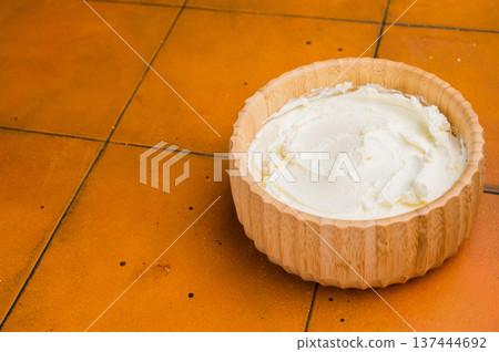 Cream texture, Mascarpone Italian cream cheese in wooden bowl. orange background. top view 137444692