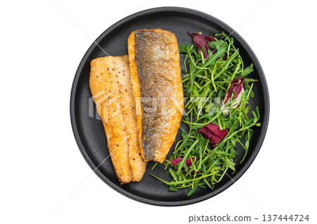 Pan fried sea bass fillets served on black plate with fresh arugula salad, gourmet seafood meal on isolated background with copy space. 137444724