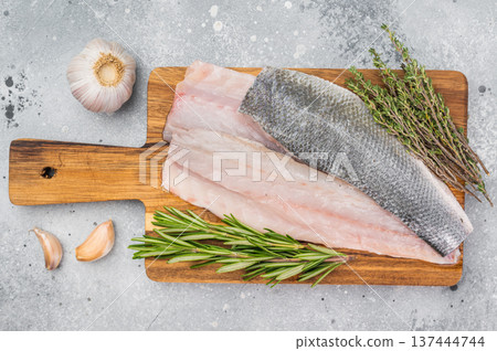 Fresh sea bass or branzino fillet portions with skin, gourmet marine seafood concept highlighting natural texture and healthy cooking preparation. 137444744