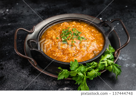 Roasted eggplant aubergine kyopolou vegetable dip served in iron skillet with parsley garnish on dark textured background top view with copy space 137444748