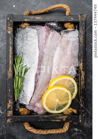 Fresh branzino or seabass fillet portions with skin on chilled ice, gourmet marine seafood composition with herbs and citrus, ideal for healthy recipe design. Fresh branzino or seabass fillet portions with skin on chilled ice, gourmet marine seafood composition with herbs and citrus, ideal for healthy recipe design. 137444749