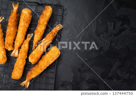 Japanese style breaded prawns with panko crust served with sauce and chopsticks, gourmet seafood appetizer concept with dramatic dark backdrop. 137444750