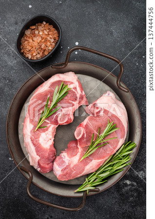 Organic lamb chump cutlets from saddle section with rosemary seasoning on dark background, raw red meat ingredient concept for restaurant kitchen or home cooking. 137444756